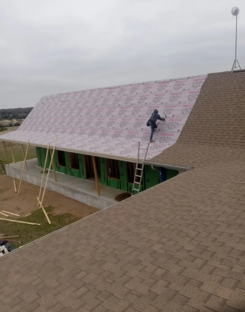 Worker preparing underlayment for a metal roof installation in Eastampton